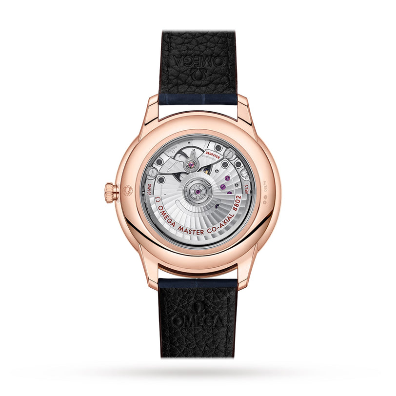 Back view of the OMEGA De Ville Prestige wristwatch with a black leather strap, revealing its Master Chronometer movement inside a rose gold case and powered by the OMEGA Co-Axial 8802 caliber for exceptional precision.