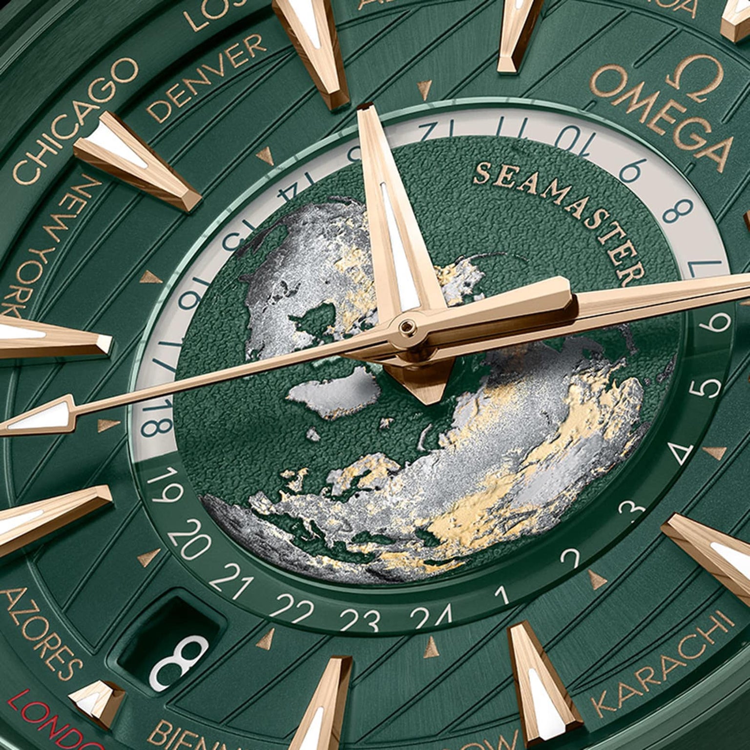 Close-up of an OMEGA Seamaster Aqua Terra 150M with a green and gold world map dial, gold hour markers, stainless steel case, and city names on the outer edge.