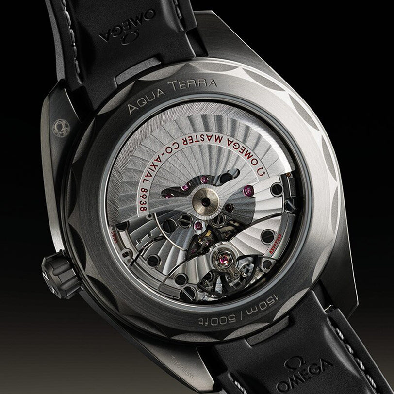 Close-up of the transparent case back of the OMEGA Seamaster Aqua Terra 150M, revealing its mechanical movement and inner components within a titanium case.