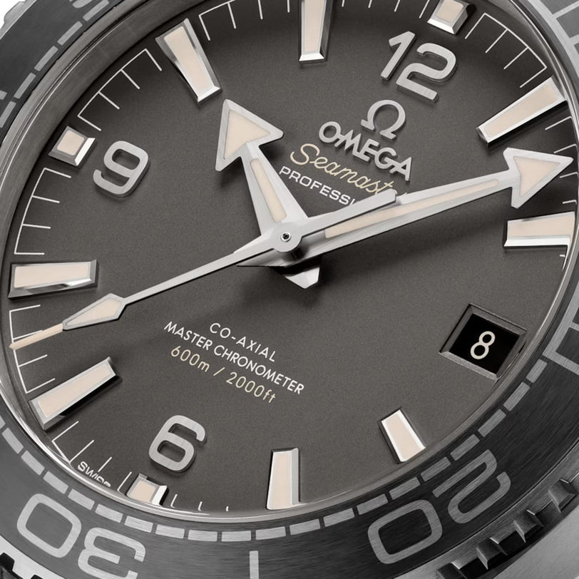 Close-up of the OMEGA Seamaster Planet Ocean 600M watch face, showcasing silver hands, a date display at 3 o’clock, and markers for 600m/2000ft water resistance—a true dive watch icon.