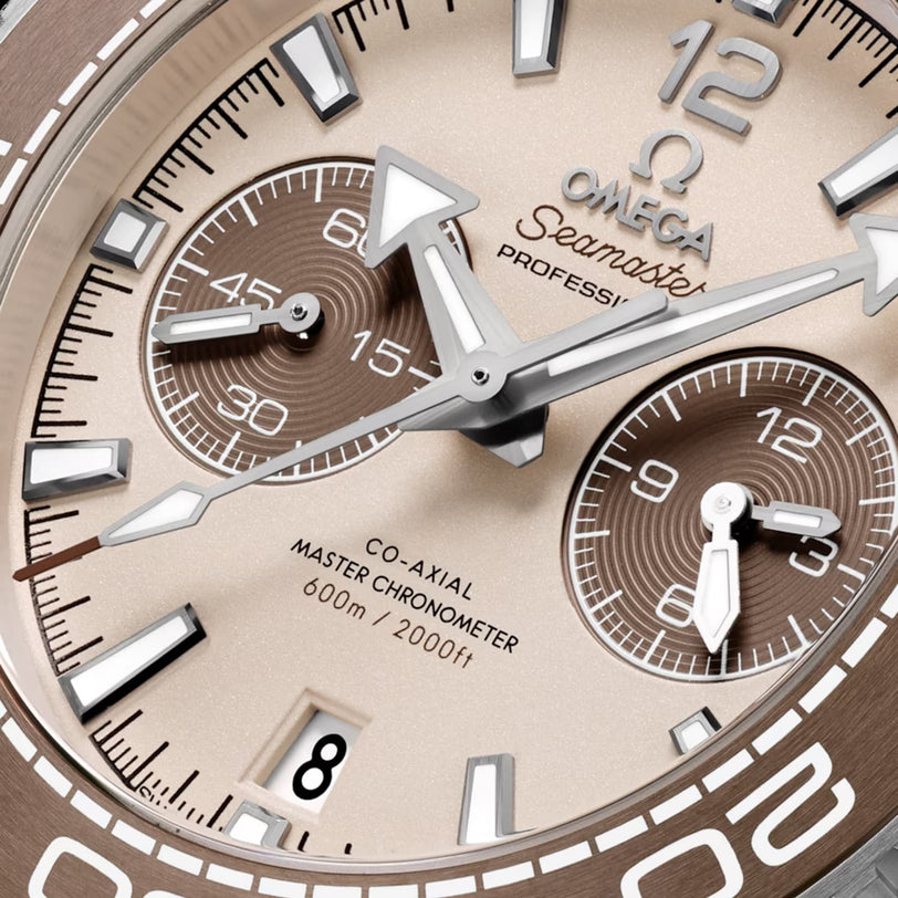 Close-up of the OMEGA Seamaster Planet Ocean 600M watch face, showing chronograph subdials, a date window, and text for 600m/2000ft water resistance and Co-Axial Master Chronometer.