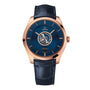 The OMEGA De Ville Tourbillon wristwatch features a blue dial, rose gold case, visible tourbillon, and blue leather strap, displayed against a white background.