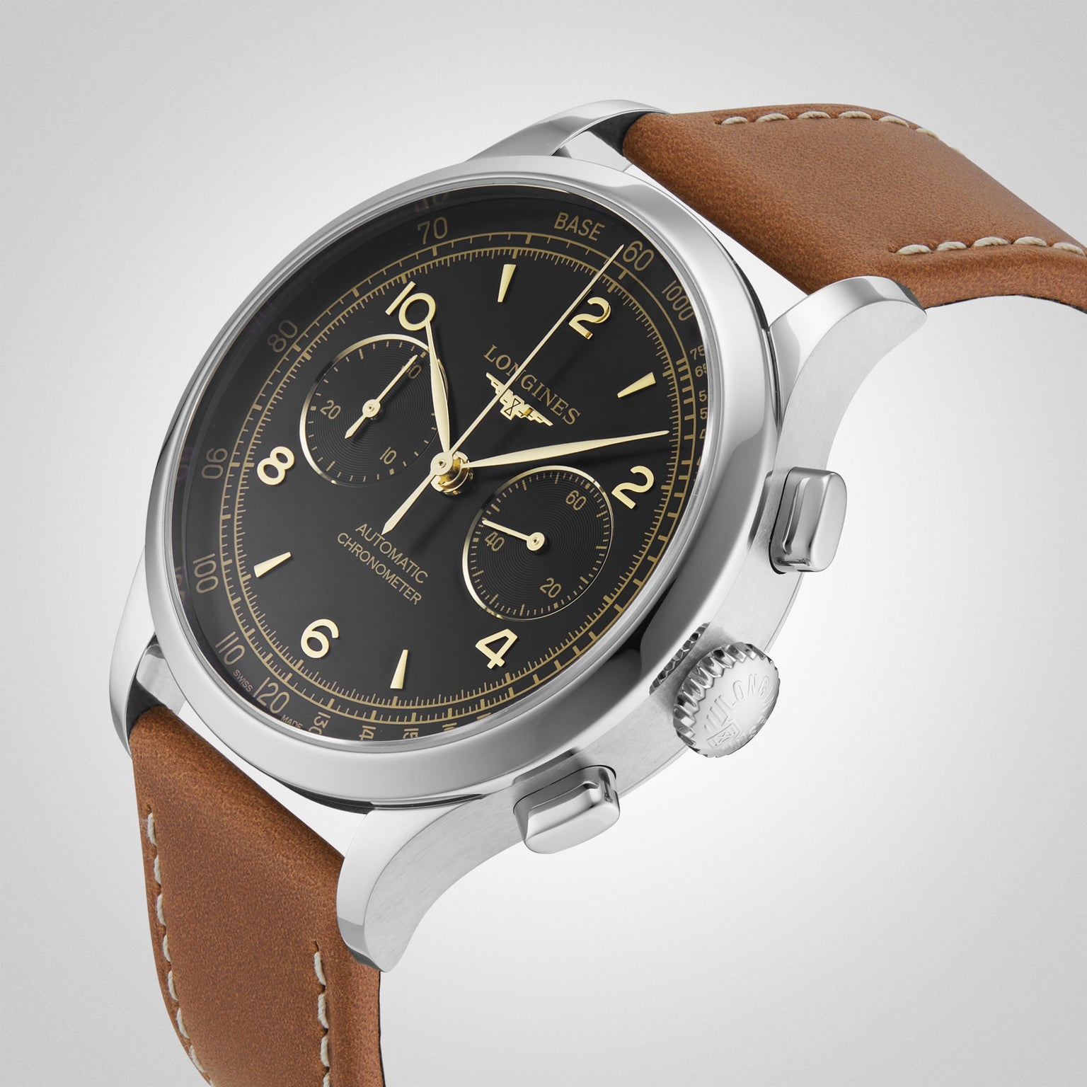A close-up of the Longines Record Chronograph wristwatch, featuring a stainless steel case, black dial with gold markings, chronograph subdials, and a brown leather strap against a plain light background.