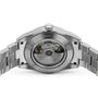 The image displays the back of the Tissot Gentleman Powermatic 80 Silicium, featuring a stainless steel case and a transparent window that reveals its intricate Powermatic 80 mechanical movement.