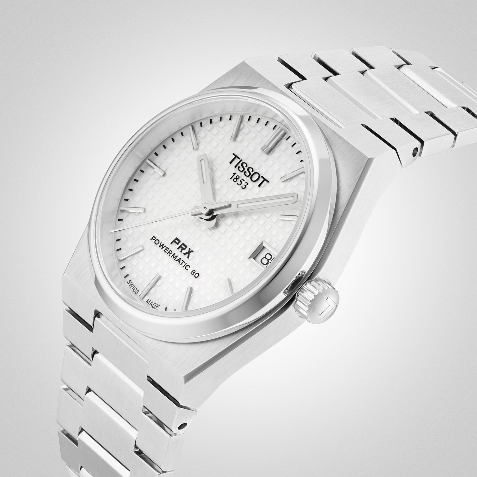 The Tissot PRX Powermatic 80 wristwatch features a silver 35mm case, white textured dial, silver hour markers, date display, and is shown at an angle on a stainless steel bracelet.