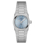The Tissot PRX is a stainless steel wristwatch with a light blue dial, silver hour markers, and a matching metal bracelet, featuring modern-vintage style and durable sapphire crystal.