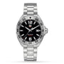 The TAG Heuer Formula 1 Date is a stainless steel wristwatch with quartz movement, a black dial with silver hour markers, date display at 3 o’clock, and a metal link bracelet.