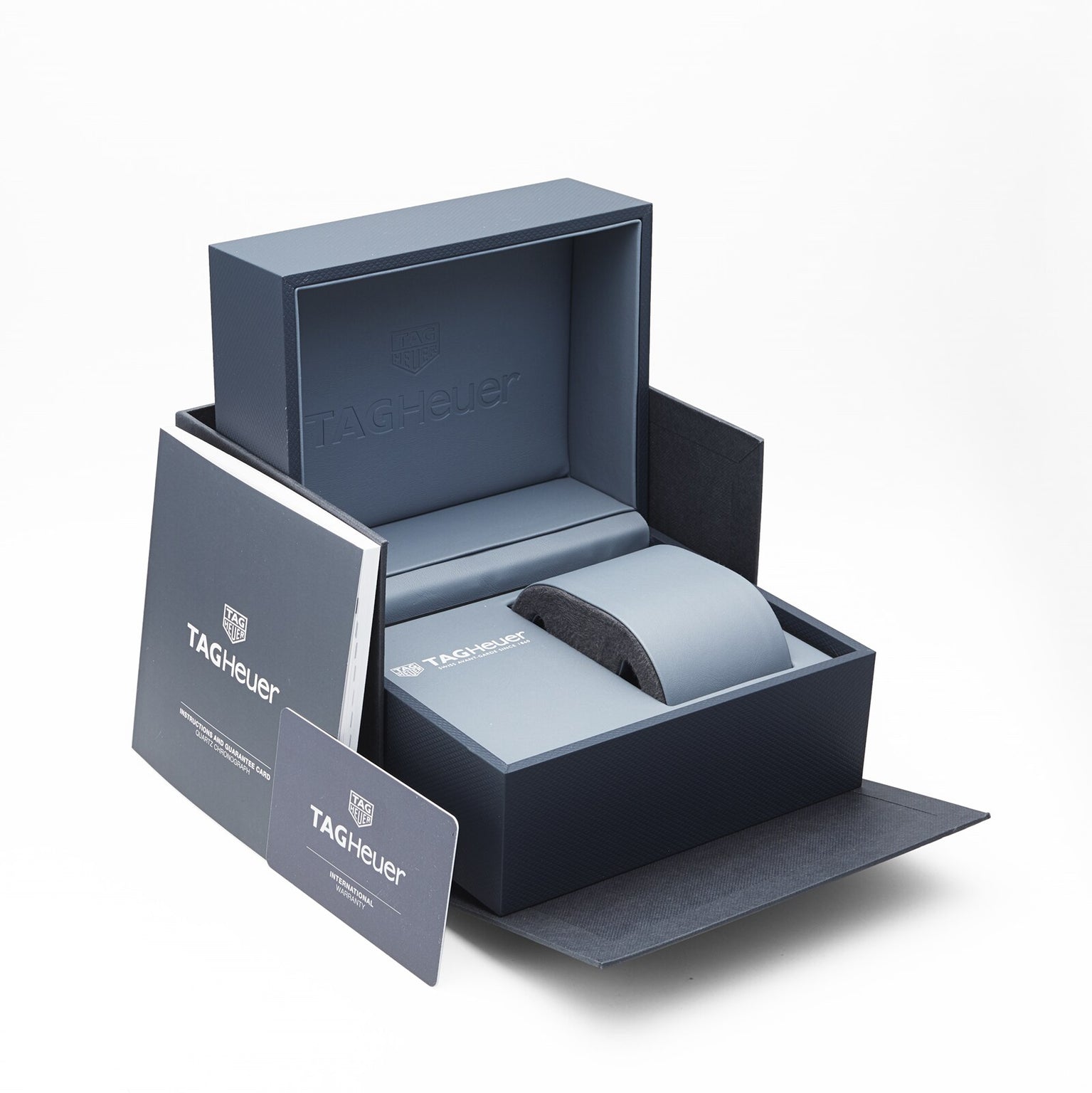 An open TAG Heuer box displays branded packaging, a booklet, and a warranty card—ideal for presenting the Formula 1 Chronograph at the center.