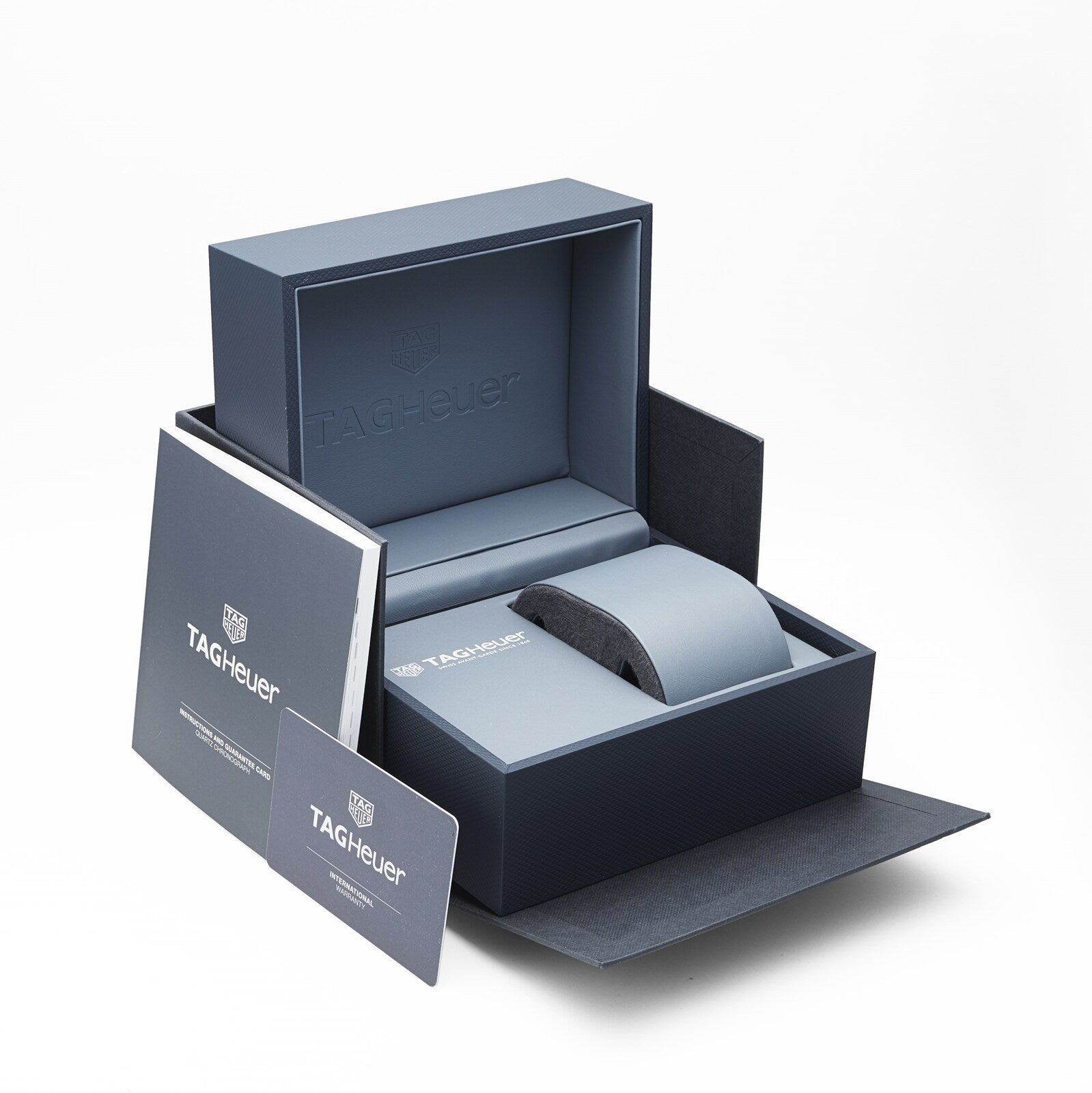 An open TAG Heuer box displays branded packaging, a booklet, and a warranty card—ideal for presenting the Formula 1 Chronograph at the center.