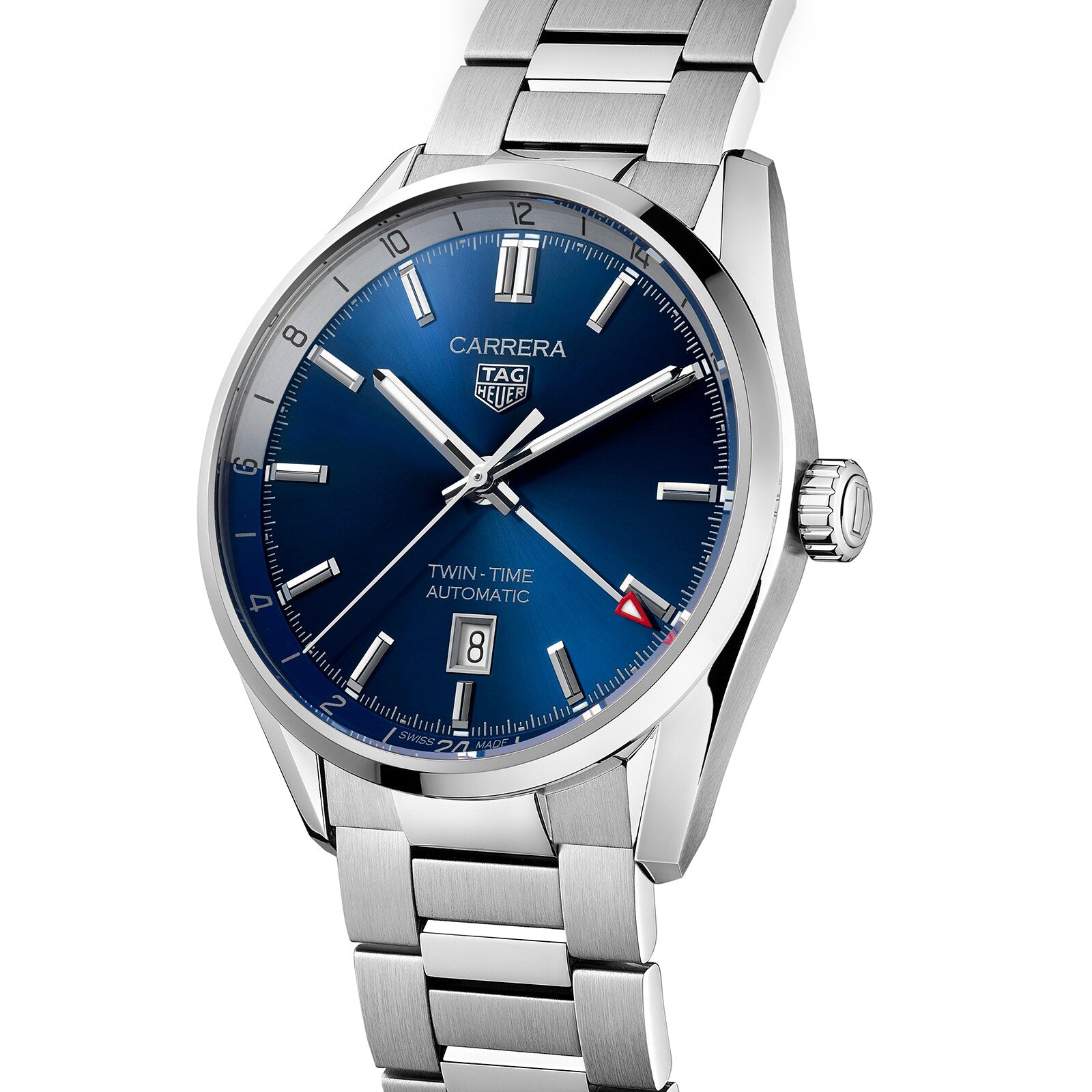 The TAG Heuer Carrera Twin-Time is a stainless steel wristwatch with a blue dial, silver hour markers, a date at six o’clock, link bracelet, and precise Calibre 7 automatic movement.
