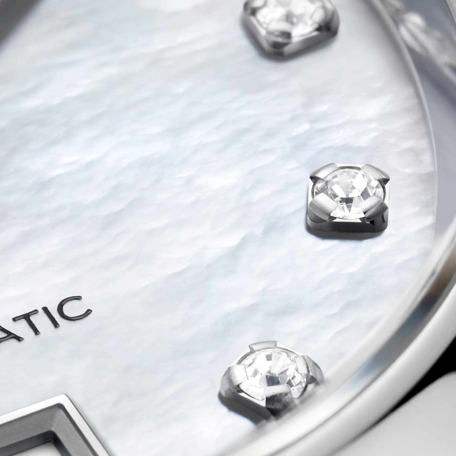 Close-up of a TAG Heuer Carrera Date watch face, showing diamond hour markers and part of the word AUTOMATIC.