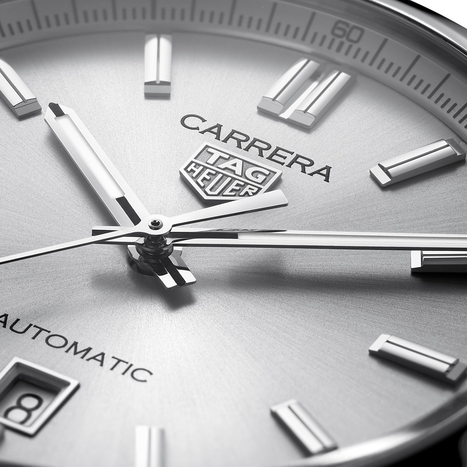 Close-up of the TAG Heuer Carrera Date watch face with silver hour markers, hands, and a partial date window, set in a 39mm steel case with automatic movement.