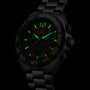 A TAG Heuer Formula 1 Chronograph wristwatch with luminescent green markers, hands, and indices glows in low light.