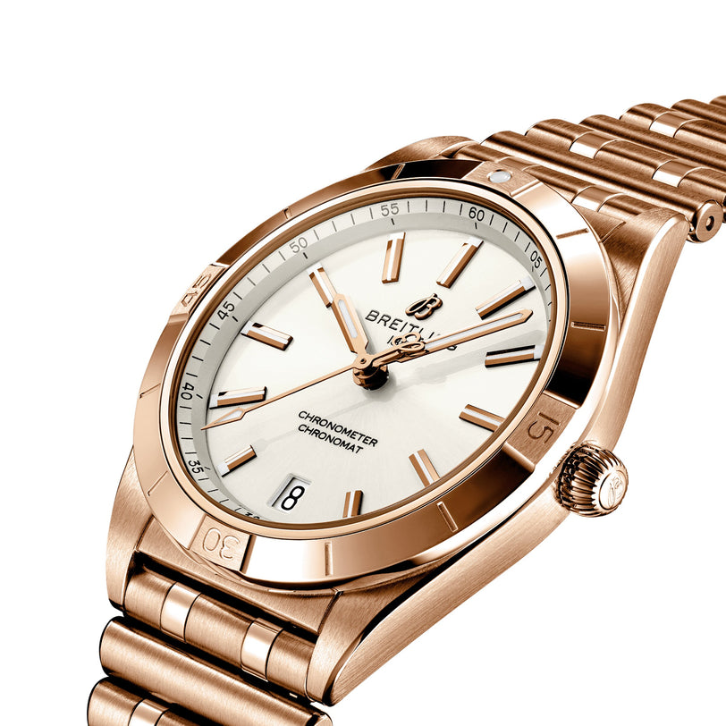 A Breitling Chronomat Automatic 36 wristwatch in gold with a white dial, gold hour markers and hands, a date window at 6 oclock, and a Rouleaux bracelet, shown on a white background.