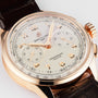The Breitling Premier B09 Chronograph 40 features a gold case, a brown leather strap, and a white dial with multiple subdials.