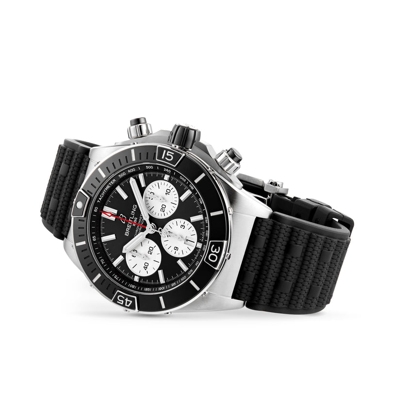 A Breitling Super Chronomat B01 44 chronograph watch in stainless steel, with a black bezel, black dial, three white subdials, and a black textured rubber strap, featuring the COSC-certified Breitling 01 calibre, shown angled on white background.