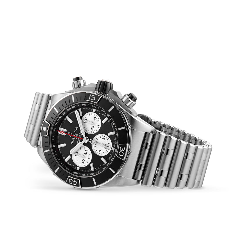 The Breitling Super Chronomat B01 44, crafted in stainless steel with a black and white dial, three subdials, and a signature Rouleaux bracelet, is photographed at an angle against a white background.