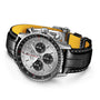 The Breitling Navitimer B01 Chronograph 43, featuring a silver case, white dial, three subdials, black leather strap with yellow lining, is displayed on a white background.