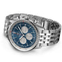 The Breitling Navitimer B01 Chronograph 46, a stainless steel wristwatch with a blue dial, three subdials, silver hour markers, and a linked metal bracelet, is displayed on a white background.