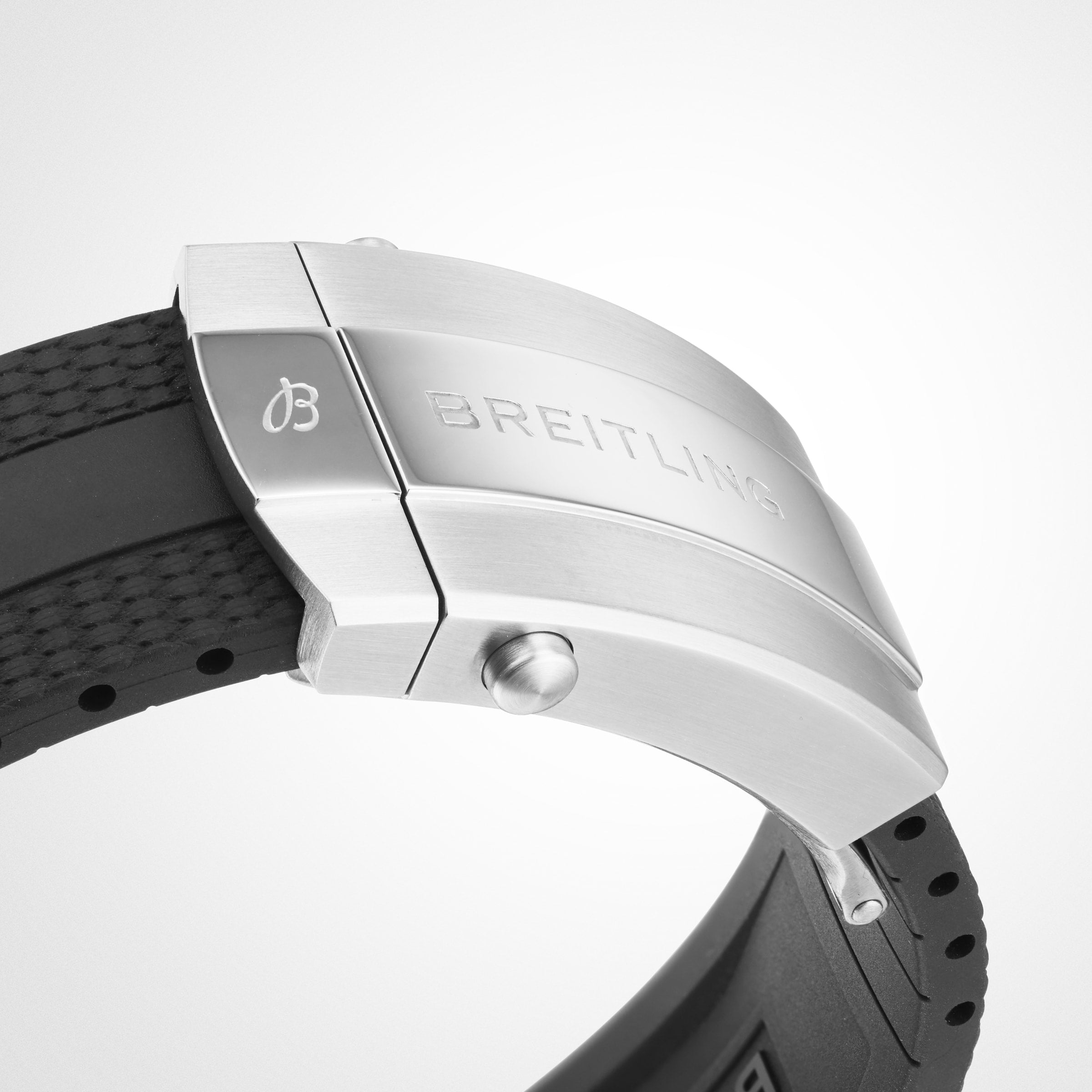 Close-up of a Breitling Superocean Automatic 42 stainless steel clasp attached to a black textured dive strap, displayed against a plain white background.