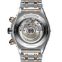 Close-up of the back of a Breitling Super Chronomat B01 44, displaying its exposed automatic movement and engraved details on a silver and 18ct rose gold bracelet.