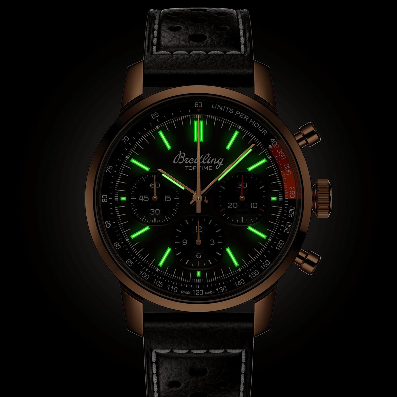 The Breitling Top Time B01 is a black watch featuring glowing green hour markers and a black leather strap.