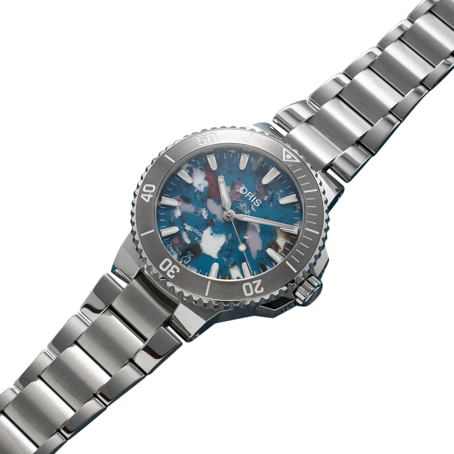 The Oris Aquis Date Upcycle Calibre 400 showcases the brand’s commitment to sustainability with its blue and white marbled dial, silver minute-marked bezel, and stainless steel link bracelet.