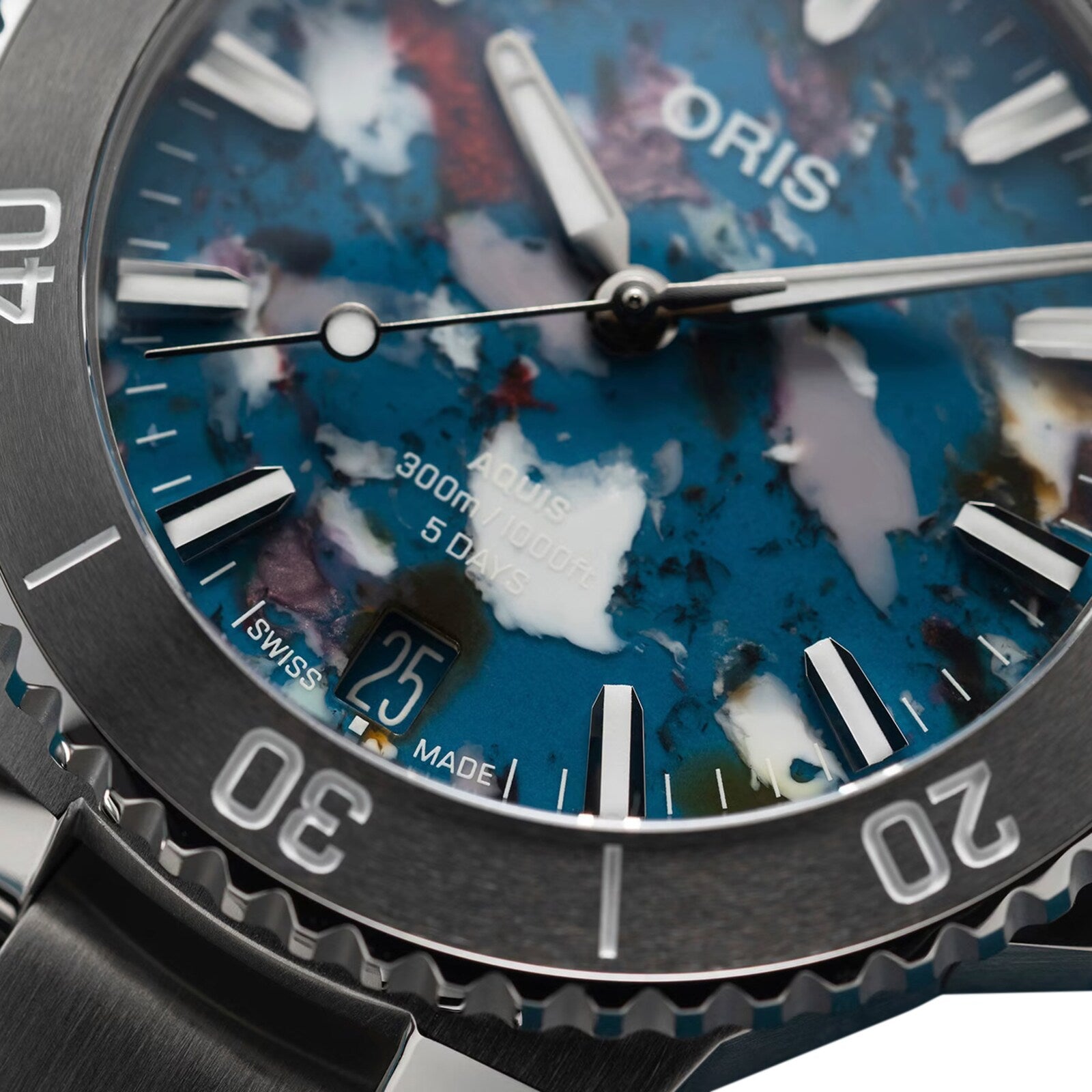 Close-up of the Oris Aquis Date Upcycle Calibre 400: a mechanical dive watch with a stainless steel bezel, silver markers and hands, date at 6 o’clock, and a multicolored marbled blue dial crafted from upcycled material.