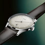 Oris watch with a black leather strap on a gradient green background