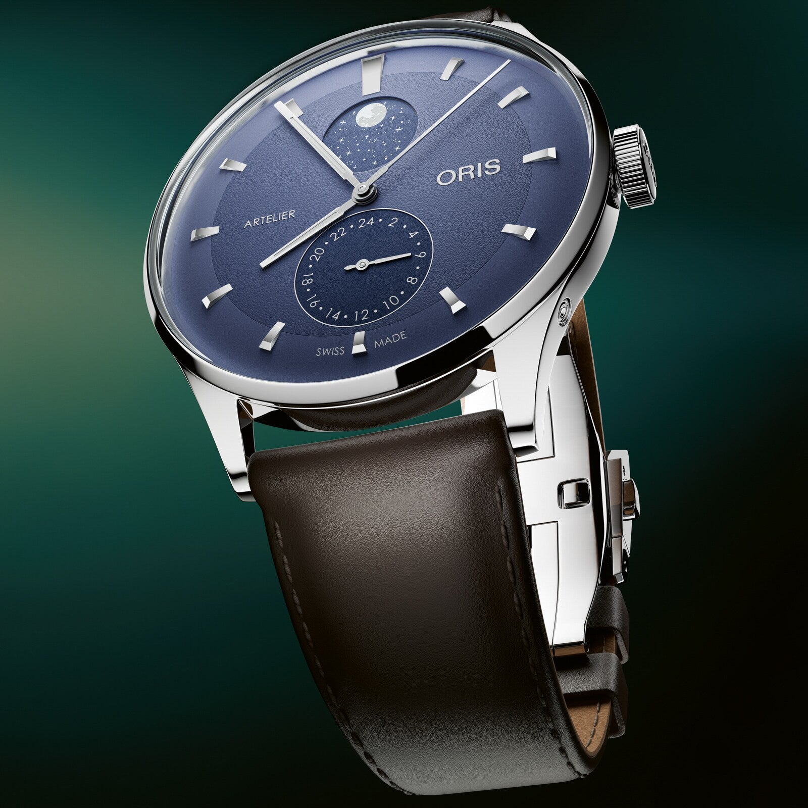 Stainless steel watch with blue dial, moonphase subdial, date window, and brown leather strap.
