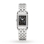 The Jaeger-LeCoultre Reverso Classic is a rectangular ladies’ watch with a black dial, silver hour markers, metal link band, and Arabic numerals at 12 and 6 o’clock. A diamond bezel at the top and bottom adds classic elegance.
