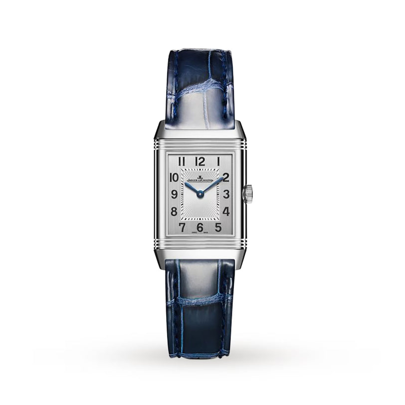The Jaeger-LeCoultre Reverso Small Duetto is a rectangular silver wristwatch with a white dial, blue hands, black Arabic numerals, and a shiny dark blue leather strap—an enduring choice among classic timepieces.