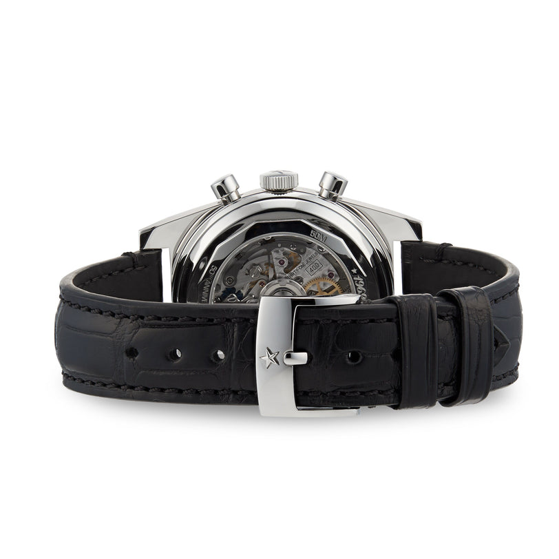 The Zenith Chronomaster Revival El Primero A384 is a mechanical wristwatch with a black leather strap, visible El Primero movement through the caseback, and a sleek silver buckle.