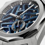 Close-up of the Zenith Defy Skyline Skeleton wristwatch, featuring a skeletonized blue dial, silver hour markers, and a small seconds subdial in a brushed metal case—an emblematic design from Zenith.