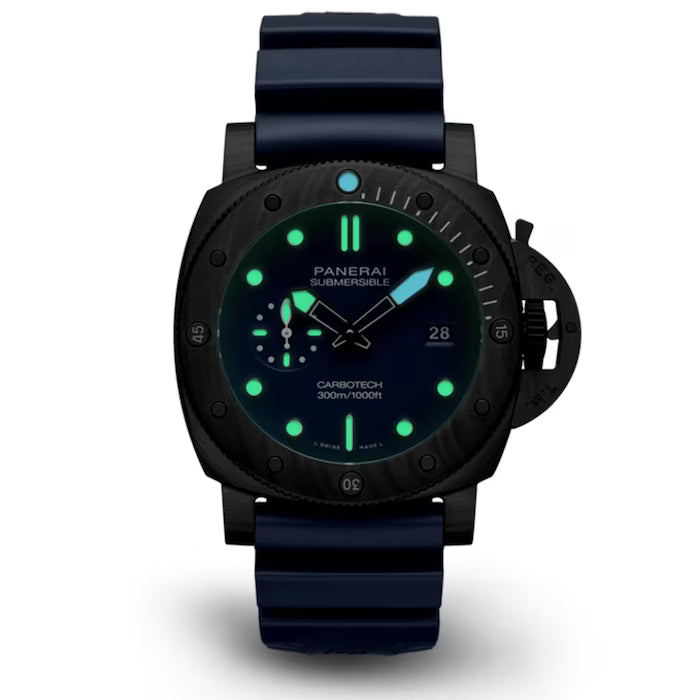 The Panerai Submersible QuarantaQuattro Carbotech Blu Abisso luxury dive watch features a black Carbotech case, blue strap, black dial with glowing green markers and hands, and a date display, shown against a white background.