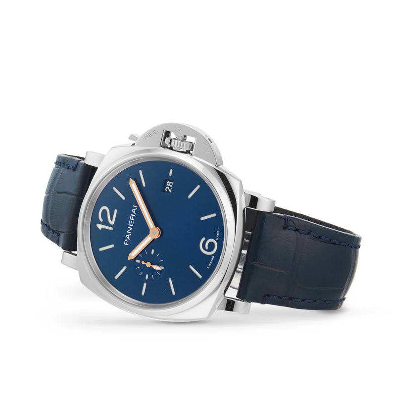 The Panerai Luminor Due wristwatch features a blue dial, silver case, blue leather strap, silver hour markers, date display, and small seconds subdial. The watch is shown tilted slightly to the left.