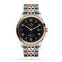 The TUDOR 1926 is a two-tone wristwatch with a black dial, gold accents, date display, and metal bracelet.