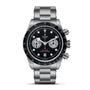 A TUDOR Black Bay Chrono stainless steel wristwatch with a black dial, three sub-dials, tachymetric bezel, and metal bracelet is photographed against a white background.
