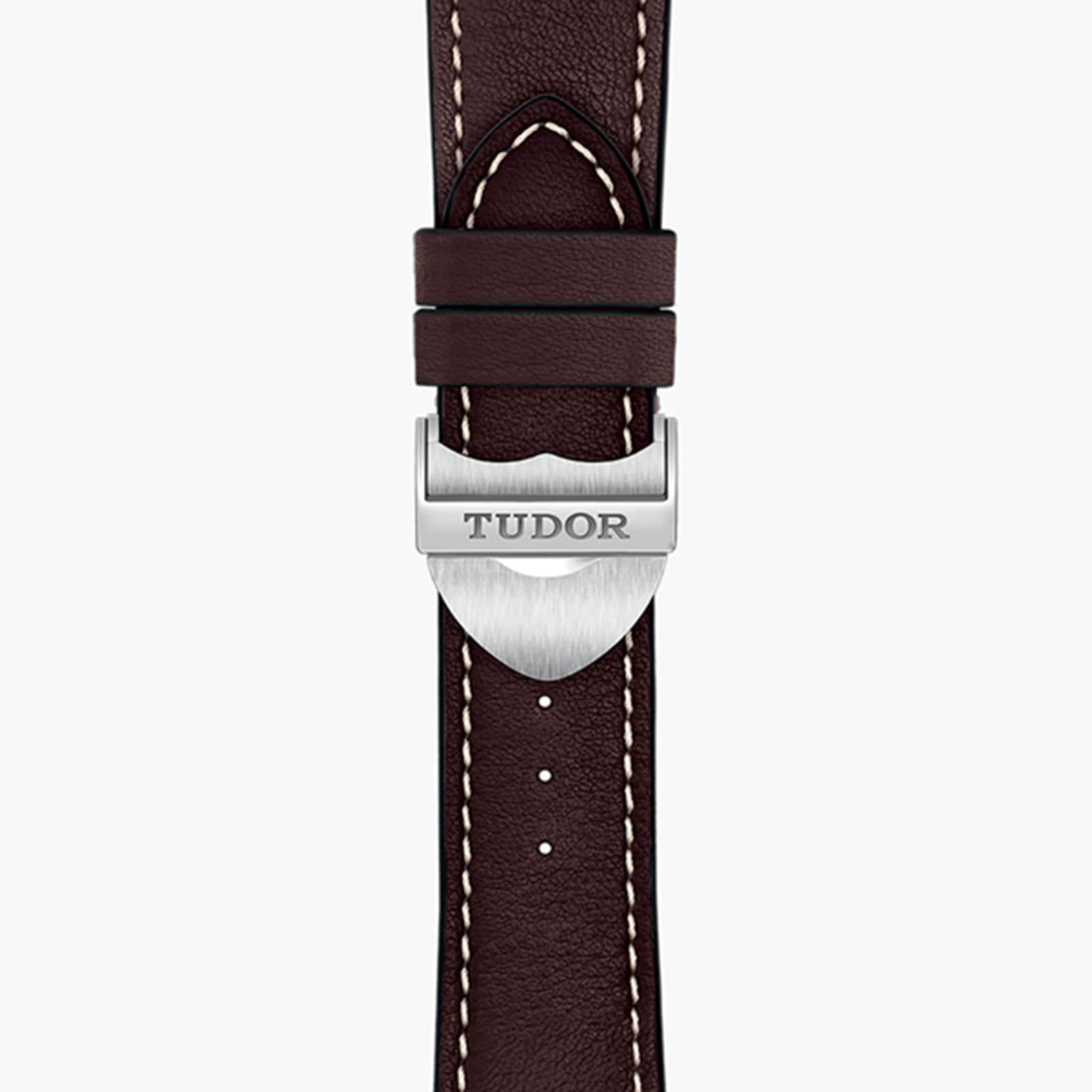 Close-up of a brown leather TUDOR 1926 watch strap featuring white stitching and a silver clasp engraved with the TUDOR logo.