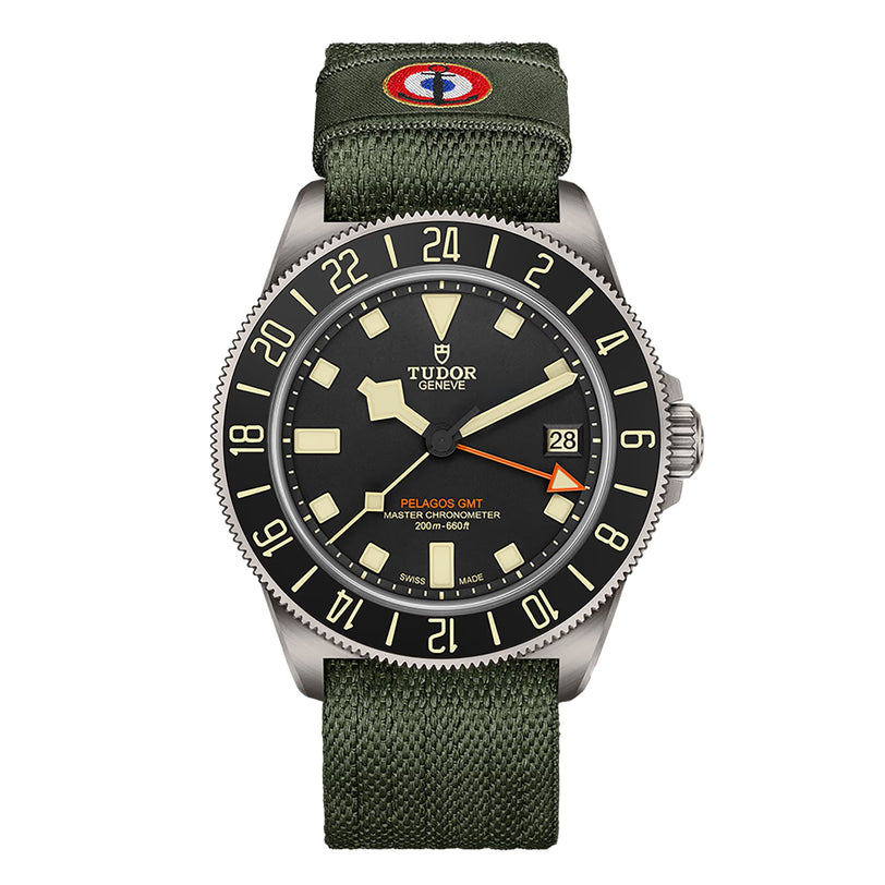 The TUDOR Pelagos FXD GMT watch features a green fabric strap, black bezel, and displays both date and time.