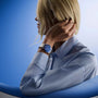 Person wearing light blue shirt with Black Bay 54 watch featuring blue dial and metal bracelet on left wrist.