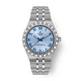 Stainless steel watch with light blue dial, Roman numerals, blue hands, and textured bezel.
