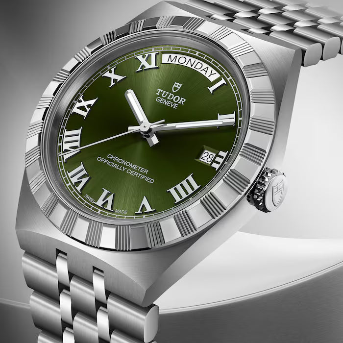 Tudor Royal stainless steel watch with green dial, Roman numerals, day-date window, and metal bracelet.