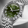 Tudor Royal stainless steel watch with green dial, Roman numerals, day-date window, and metal bracelet.