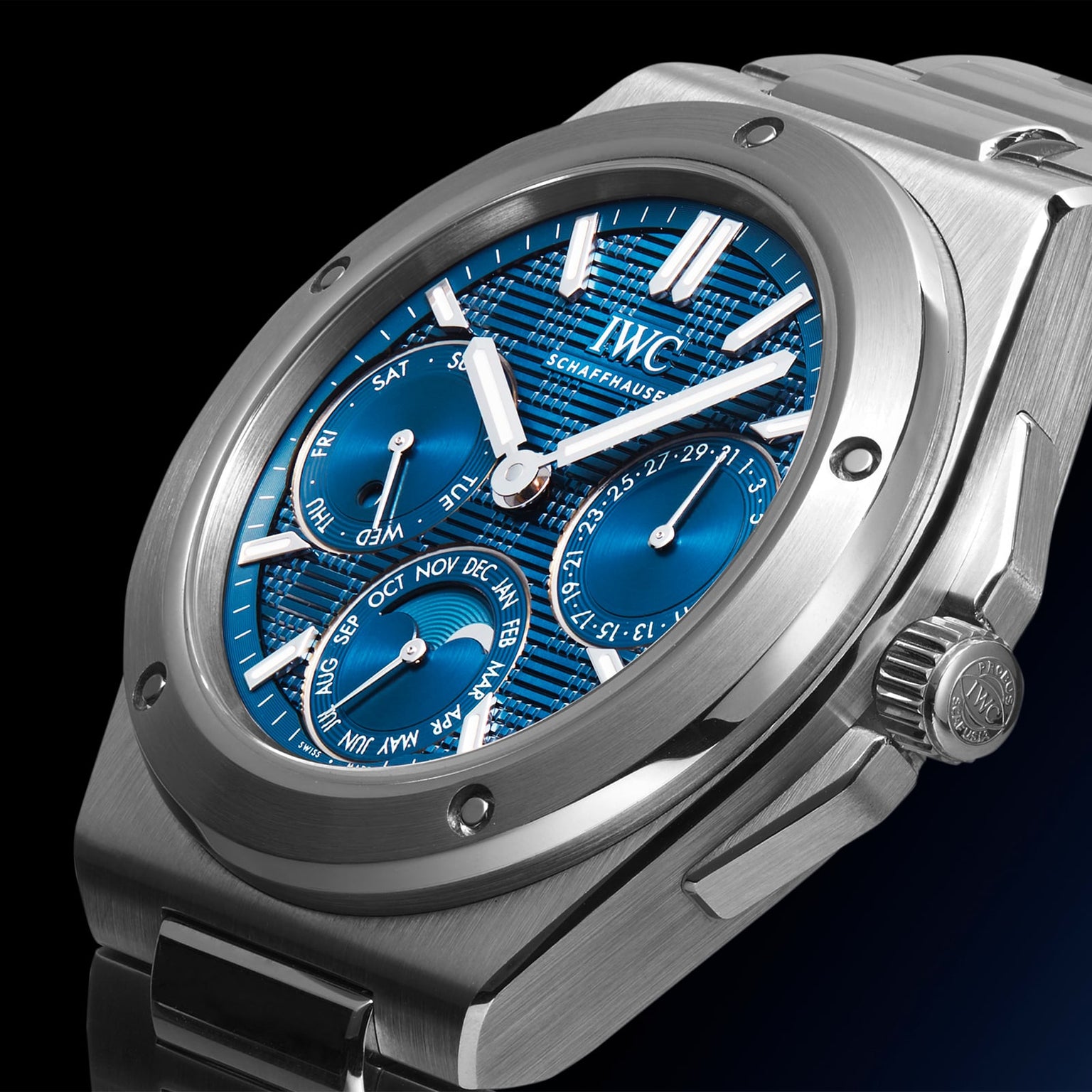 Close-up of the IWC Schaffhausen Ingenieur Perpetual Calendar 41, a stainless steel watch with a blue textured dial, day, date, and month subdials, metal bracelet, and Gérald Genta-inspired design against a dark backdrop.