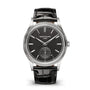 The Patek Philippe Calatrava 6119G-001 is a black wristwatch with a leather strap and silver accents, displayed against a white background.