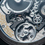 Close-up of the Speake Marin Openworked Tourbillon Black DLC, showcasing intricate watch gears and mechanisms with engraved gold and silver text on the metal components.
