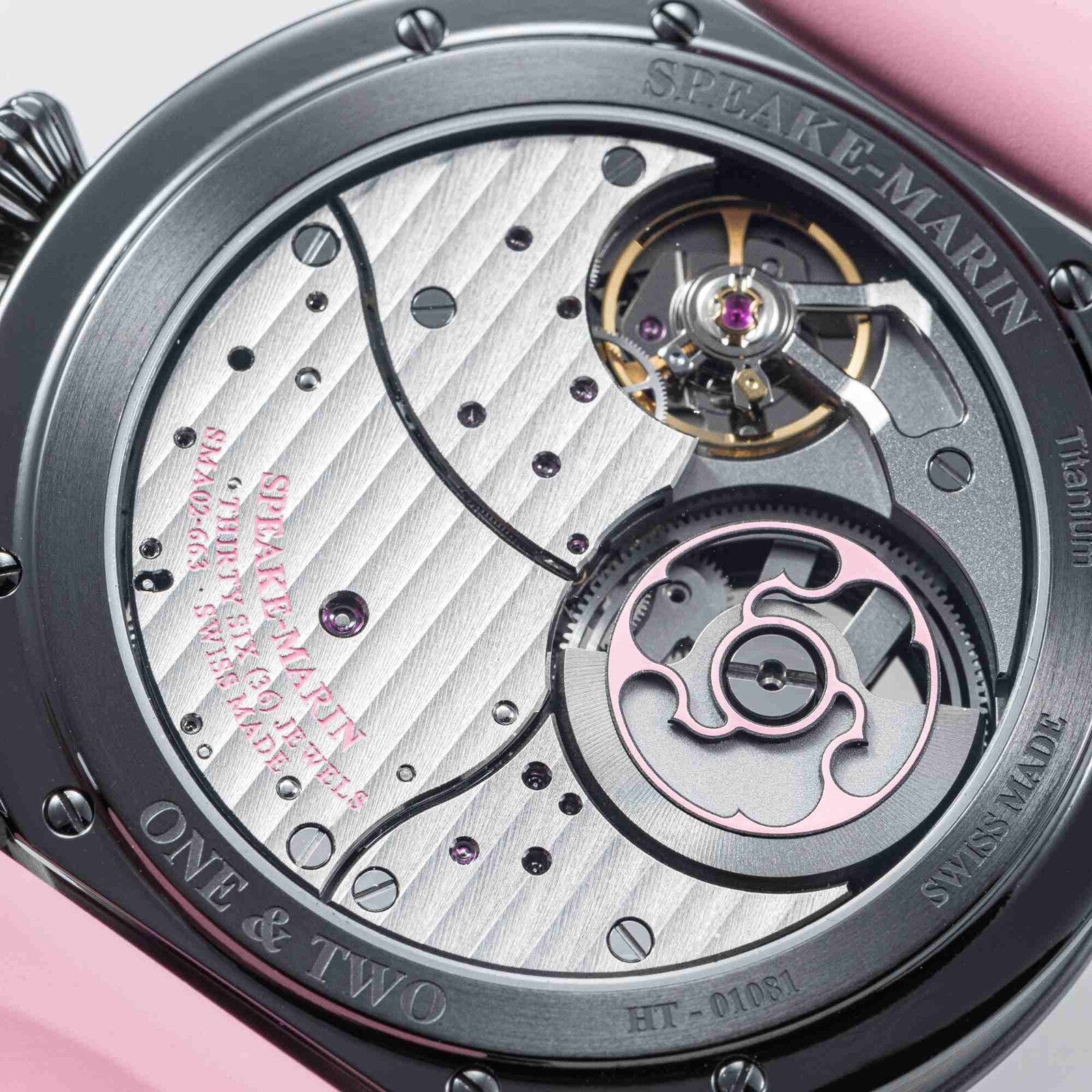 Close-up of the Speake Marin Dual Time Pink watch movement, showcasing its intricate gears, screws, and detailed metal engravings.