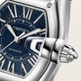 Cartier Roadster watch with blue dial, Roman numerals, silver hands, and stainless steel case with crown detail.