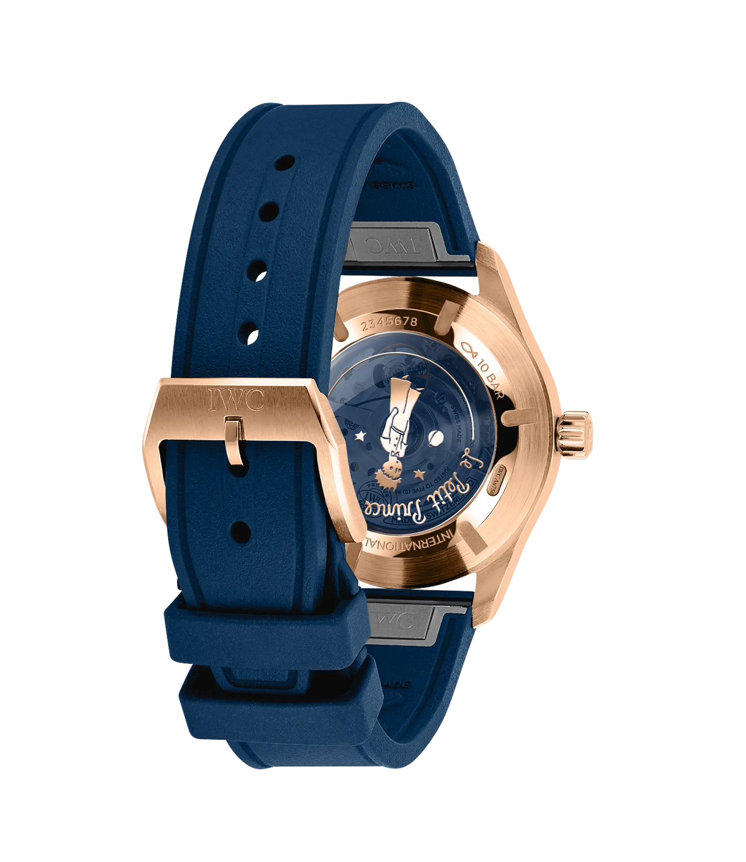 Rose gold pilot watch with dark blue dial featuring Le Petit Prince illustration, blue rubber strap, and visible caseback sho